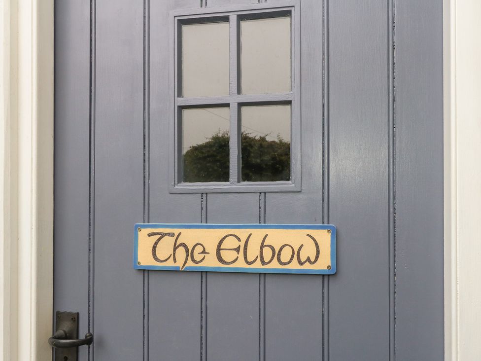 A door with a window and a sign that reads The Elbow at The Elbow in Frampton