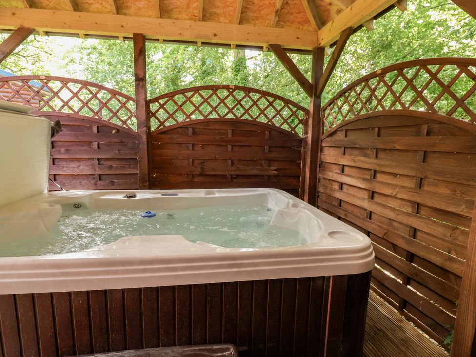 A hot tub enclosed by wooden panels at The Red in Llanerch Park near St Asaph