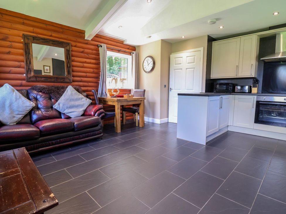 A living room with a sofa and table at The Red in Llanerch Park near St Asaph