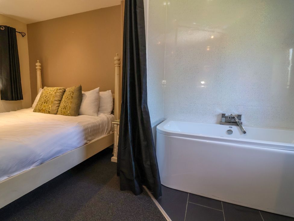 A bedroom with a bed and a bathtub at The Red in Llanerch Park near St Asaph