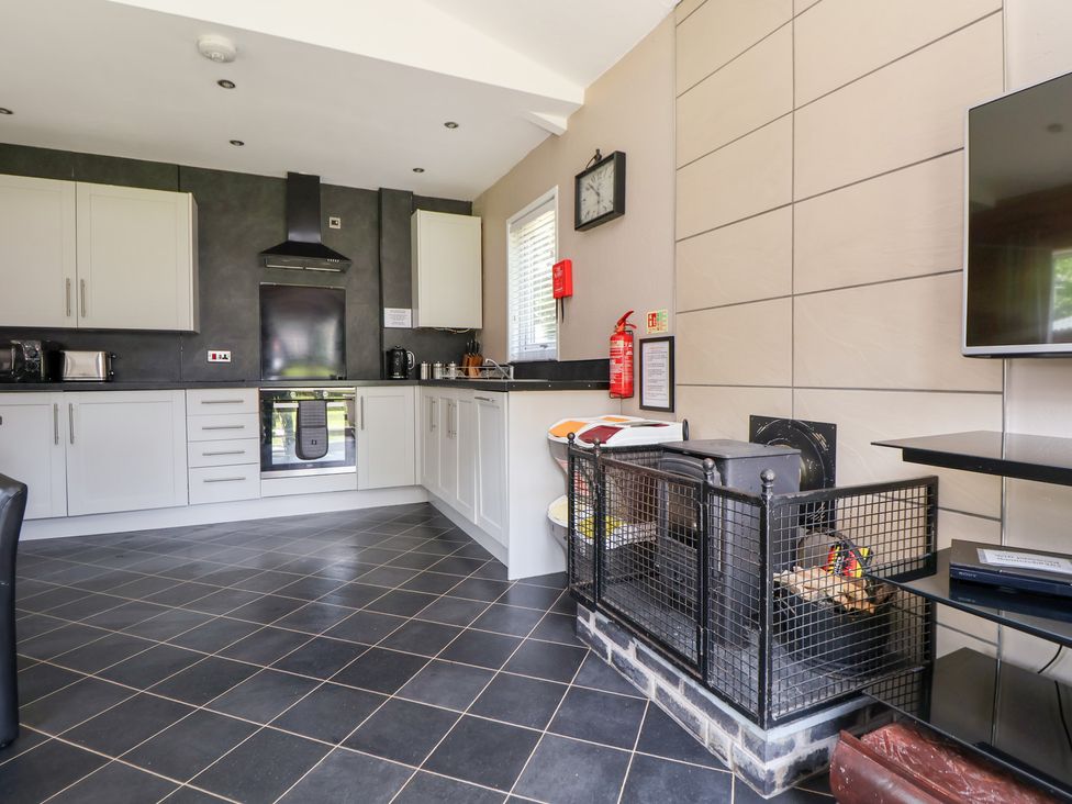 A kitchen with cabinets and an oven at The Fallows in Llanerch Park near St Asaph