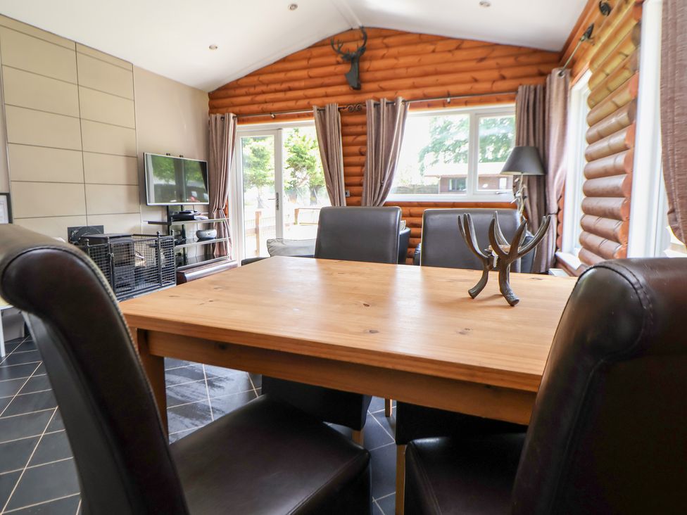 A dining room with a table and chairs at The Fallows in Llanerch Park near St Asaph