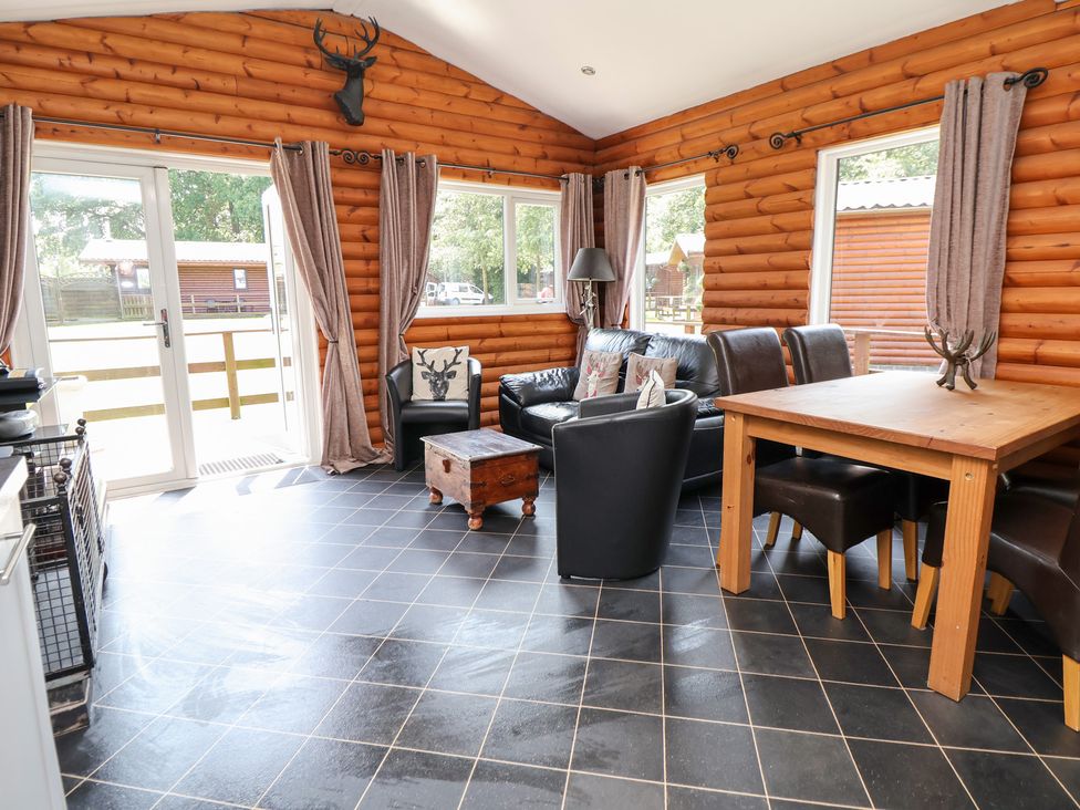 A snug area with seating and a dining table at The Fallows in Llanerch Park near St Asaph