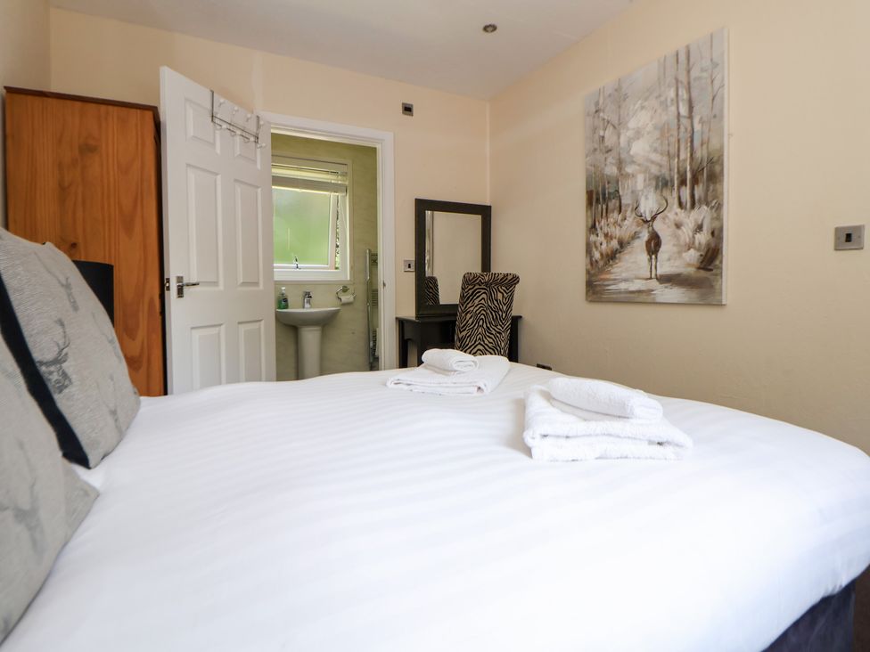 A bedroom with a bed and a mirror at The Fallows Llanerch Park near St Asaph