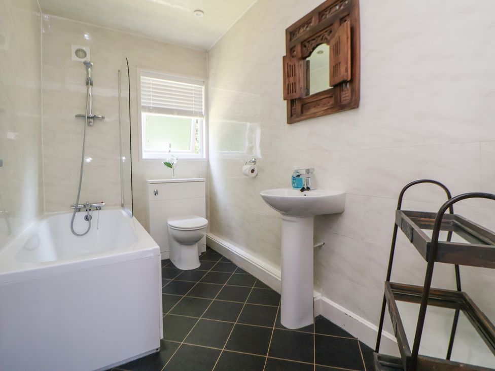 A bathroom with a bathtub, toilet, and wash basin at The Fallows in Llanerch Park near St Asaph