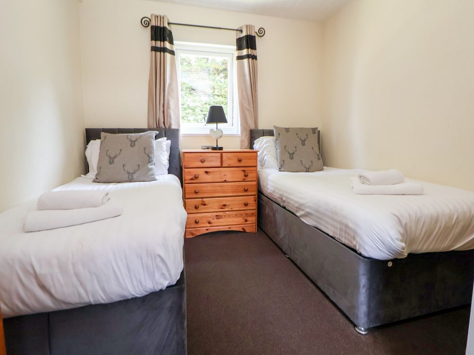 A bedroom with two beds and drawers at The Fallows in Llanerch Park near St Asaph