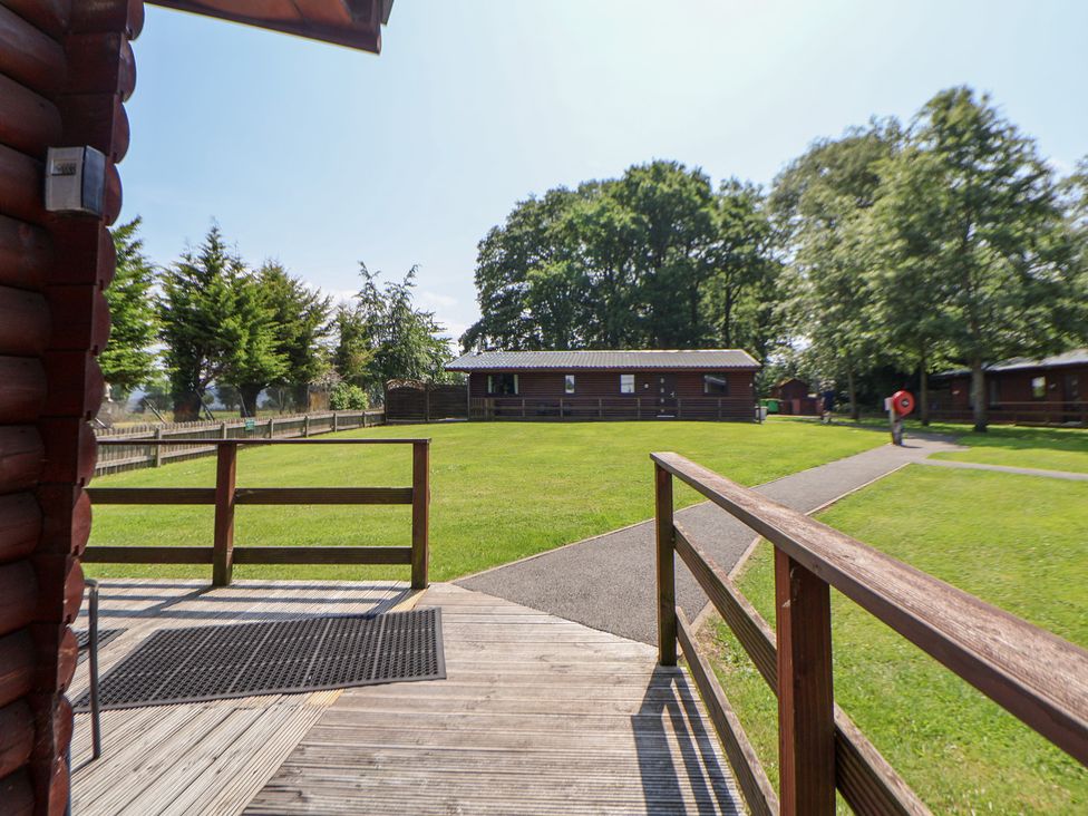 An outdoor area with cabins and grass at The Fallows Llanerch Park near St Asaph