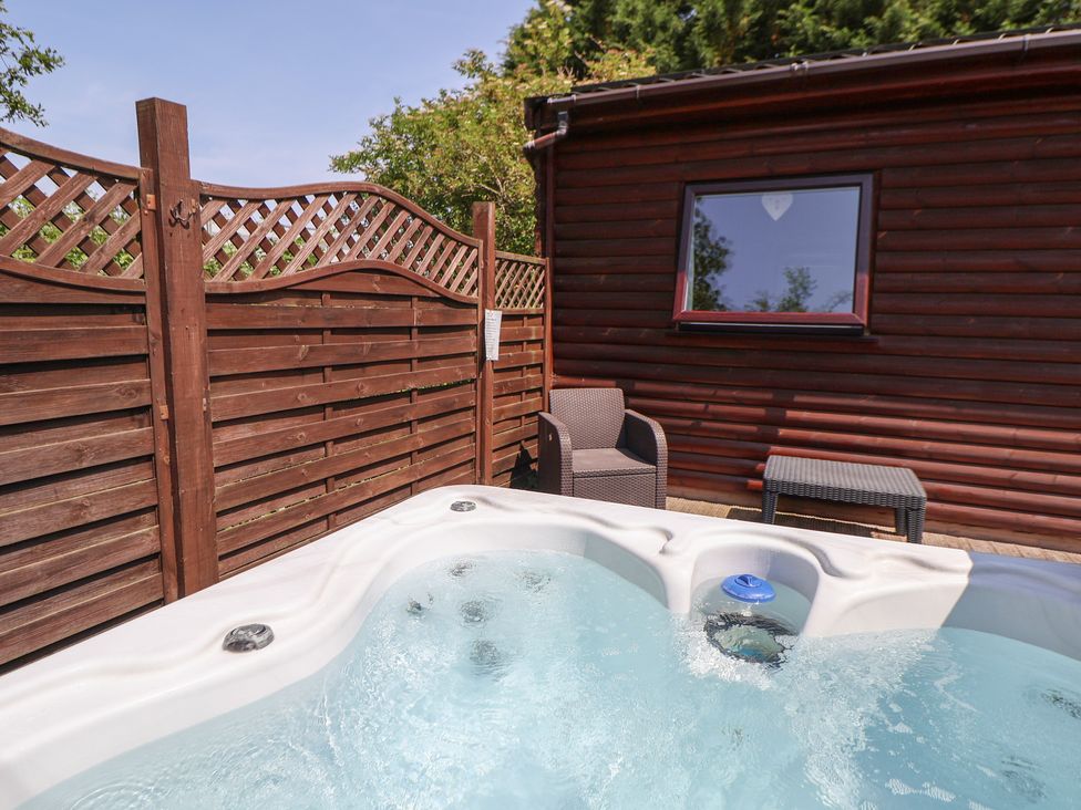 A hot tub and seating area in a garden at The Fallows near Llanerch Park near St Asaph