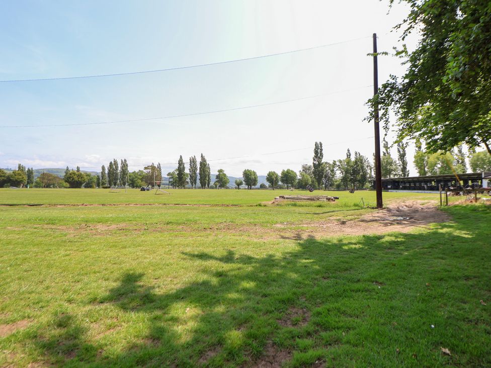 An outdoor area with grass and trees at The Fallows Llanerch Park near St Asaph
