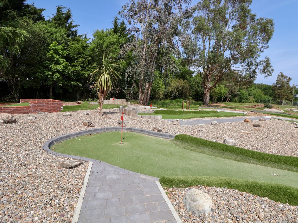 An outdoor area with a golf putting green and pathway at The Fallows in Llanerch Park near St Asaph