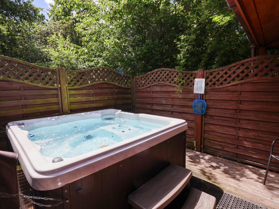 A hot tub surrounded by wooden fencing at The Roe in Llanerch Park near St Asaph