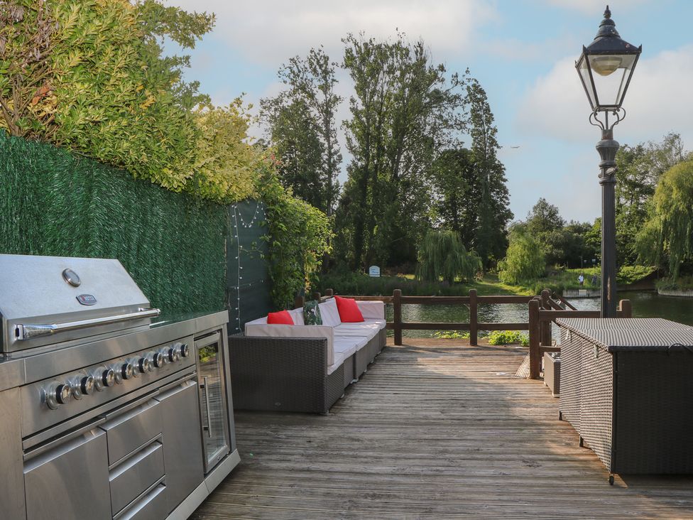 An outdoor area with a grill and seating at Coventina in Wraysbury