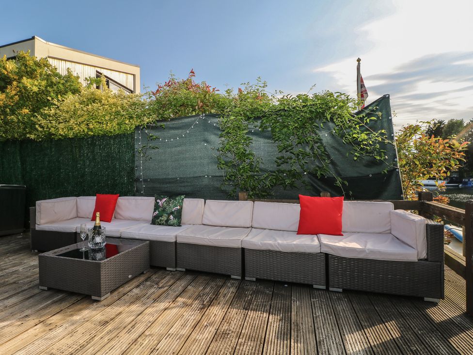 An outdoor sofa with a coffee table on a patio at Coventina in Wraysbury