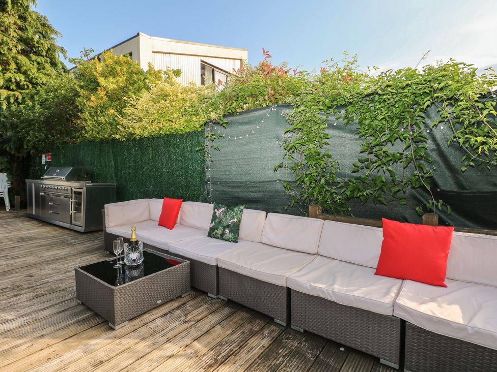 An outdoor area with a sofa and barbecue grill at Coventina in Wraysbury