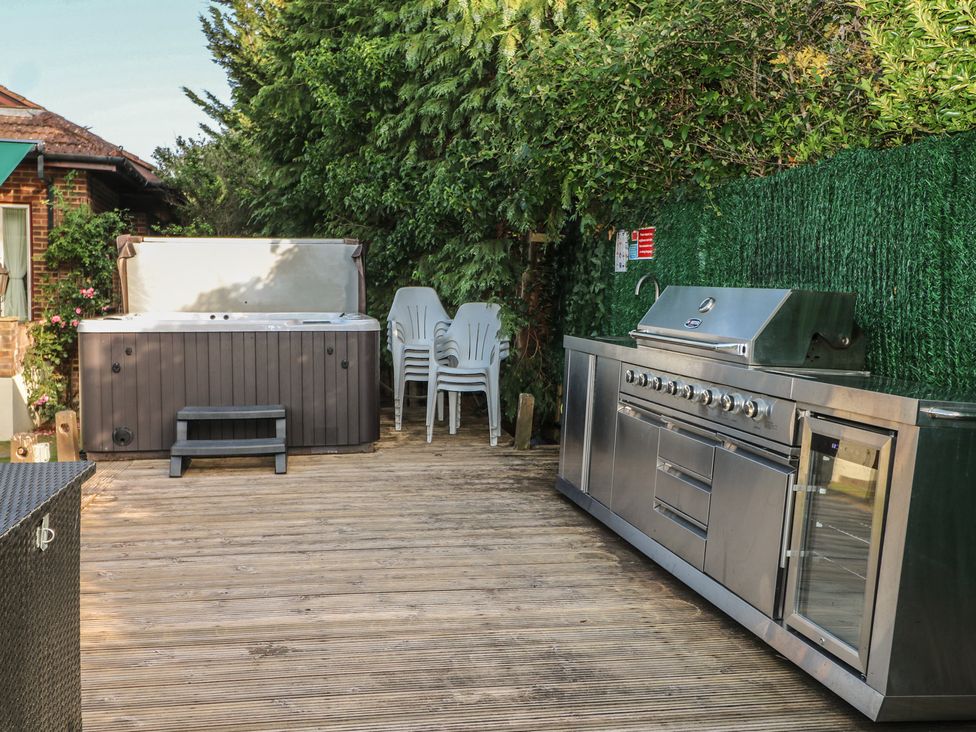 An outdoor area with a hot tub and grill at Coventina in Wraysbury