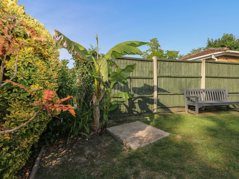 A garden with a bench and plants at Thames Retreat in Wraysbury