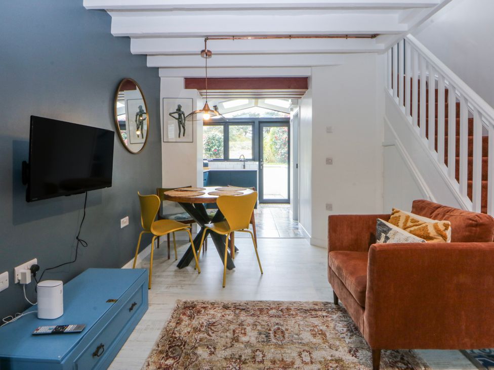 A living room with a table and chairs at East meets West Criccieth