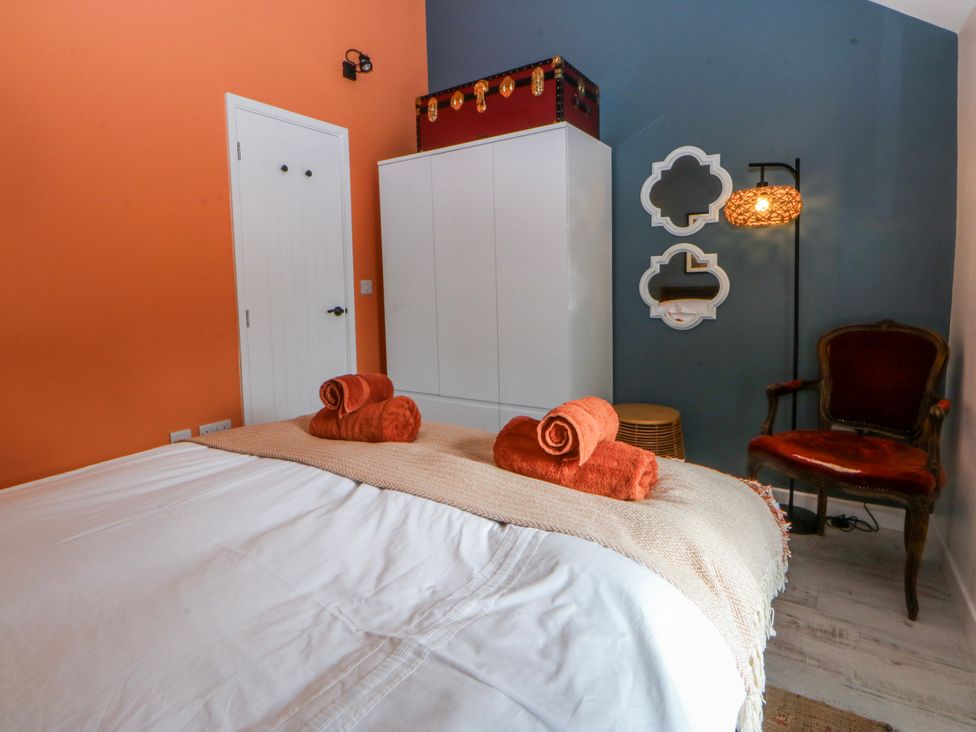 A bedroom with a bed and towels at East meets West in Criccieth