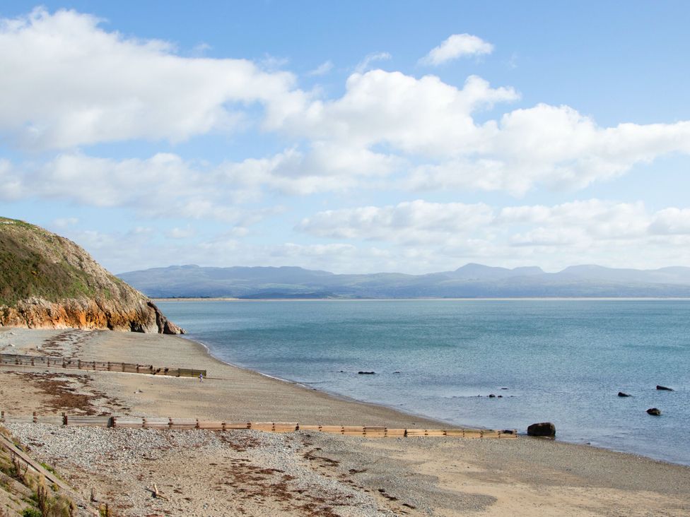 A beach view with water and mountains at East meets West Criccieth