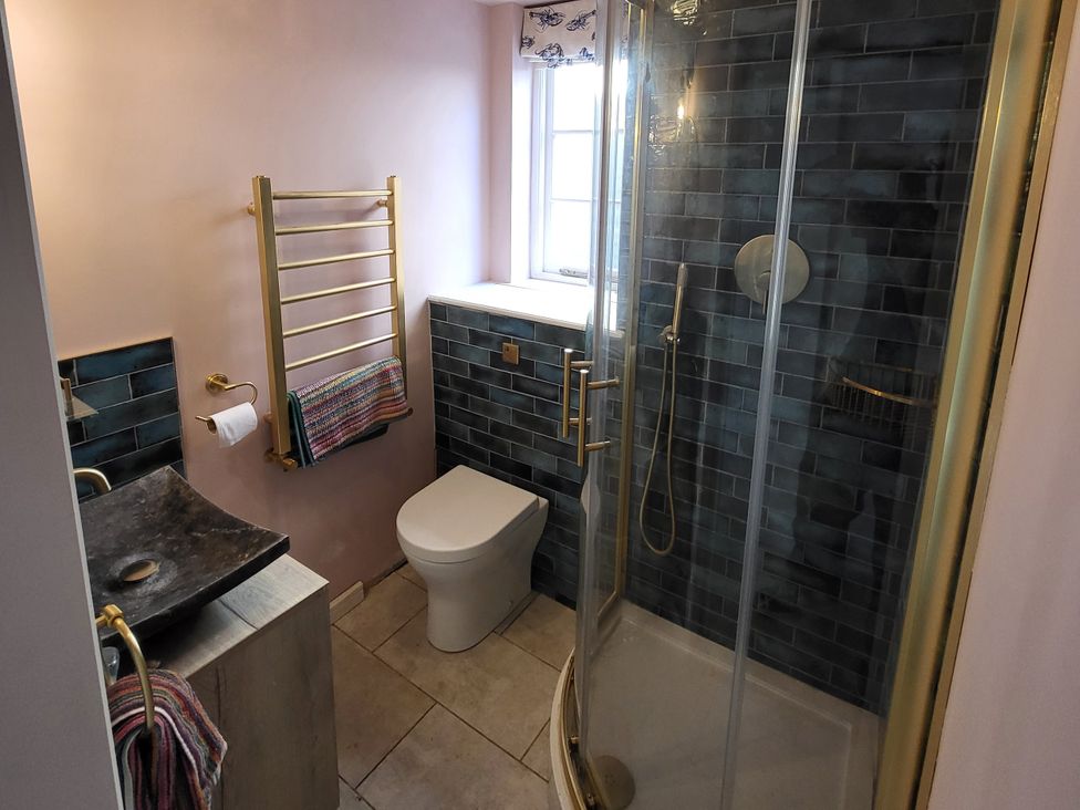 A bathroom with a shower, toilet, and sink at Fishermans Locker in West Bay