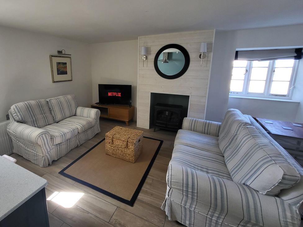 A living room with a tv and sofas at Fishermans Locker in West Bay