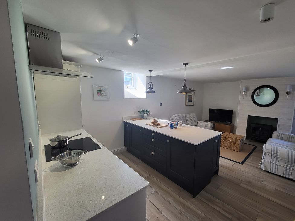 A kitchen with an island and stove at Fishermans Locker in West Bay
