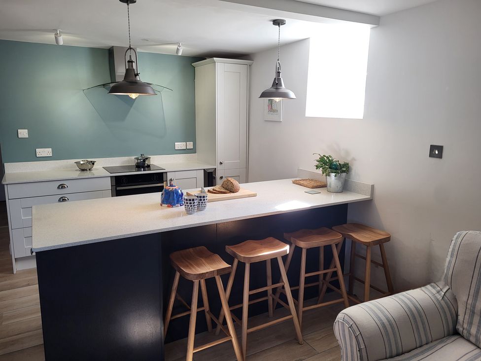 A kitchen with bar stools and countertop at Fishermans Locker in West Bay