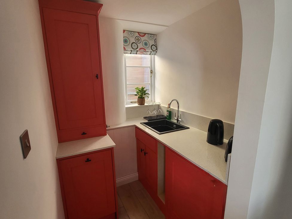 A kitchen with a sink and cupboards at Fishermans Locker in West Bay