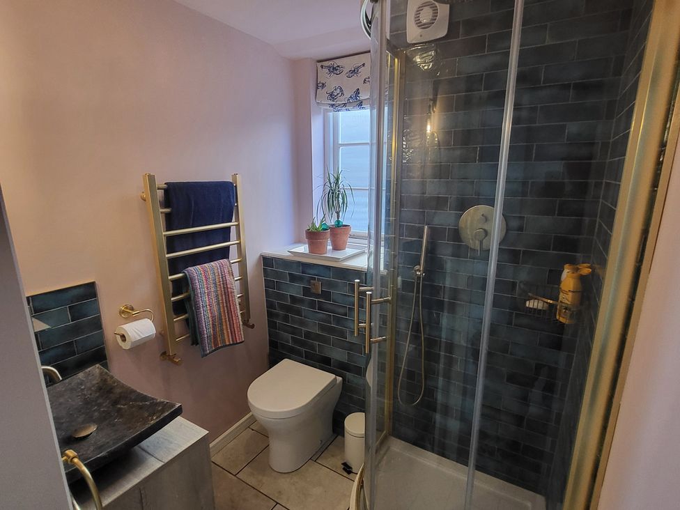 A bathroom with a shower, toilet, and sink at Fishermans Locker in West Bay