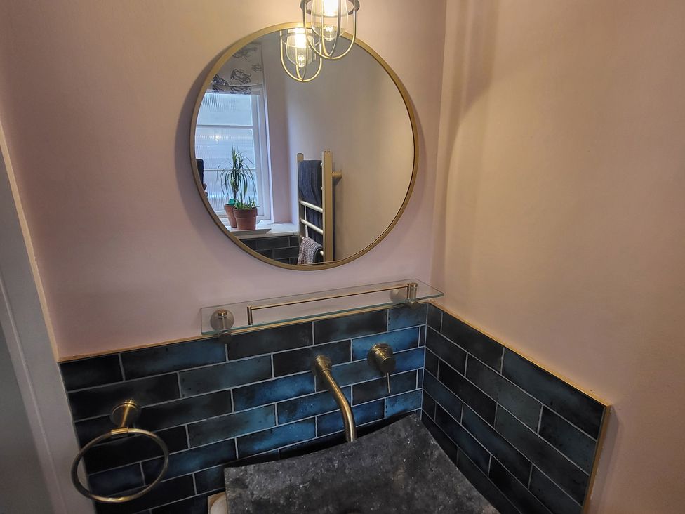 A bathroom with a sink and mirror at Fishermans Locker in West Bay