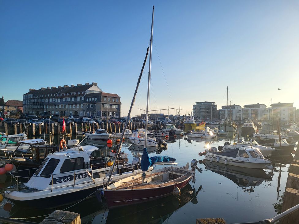 A marina with boats and buildings at Fishermans Locker in West Bay