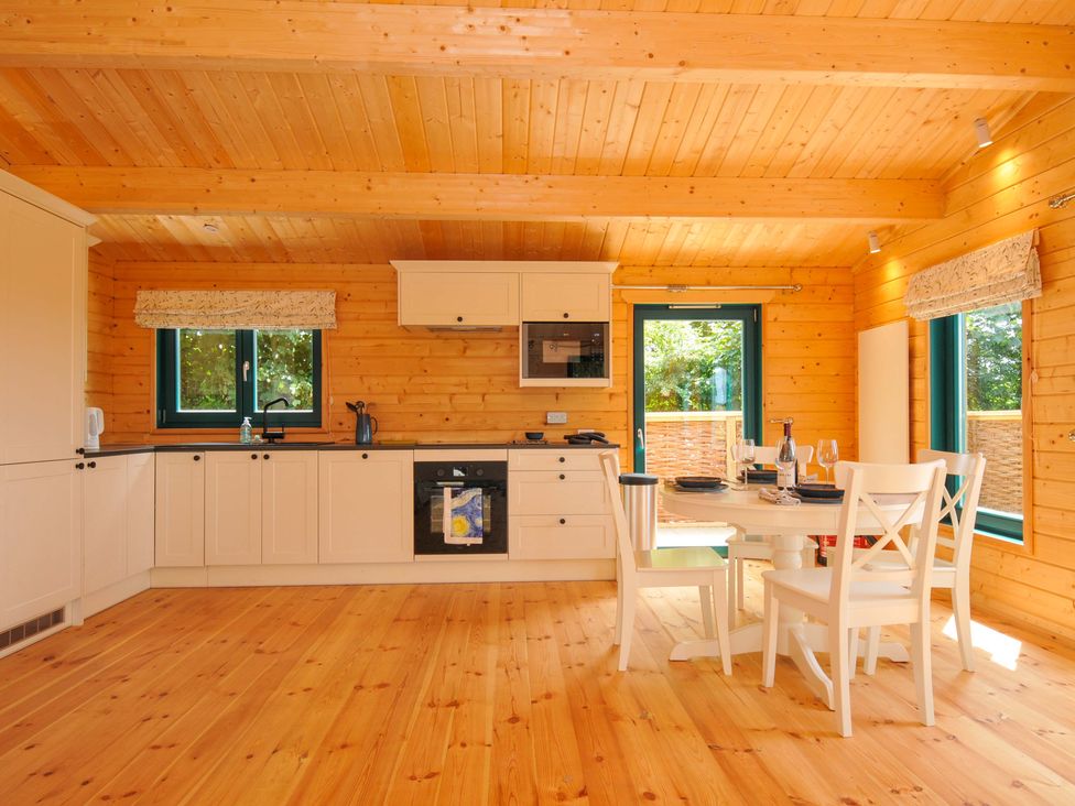 A kitchen with a dining table and four chairs at Owl Lodge in Menheniot