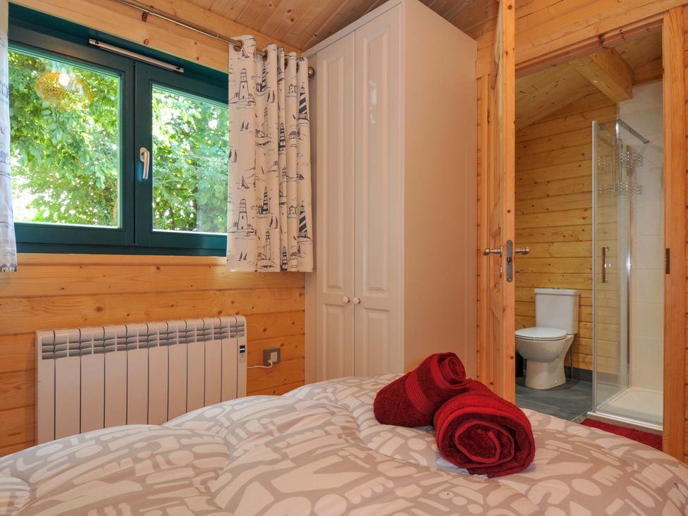 A bathroom with a shower and toilet at Owl Lodge Menheniot