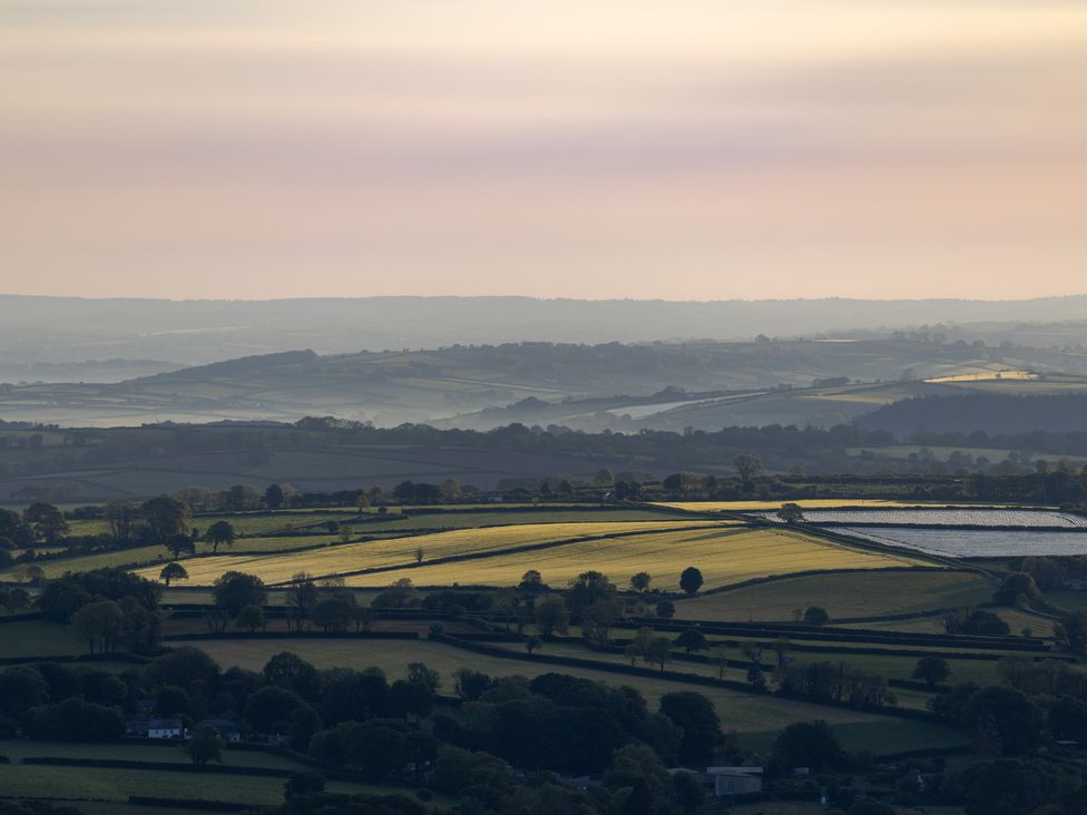 A landscape view of fields and hills in Menheniot at Owl Lodge