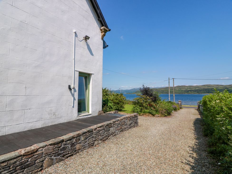 A side view of a house with a pathway leading to water at Altafearn in Tighnabruaich