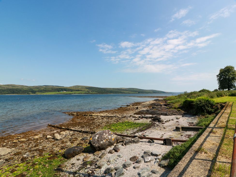 A shoreline with rocks and grass near the water at Altafearn in Tighnabruaich