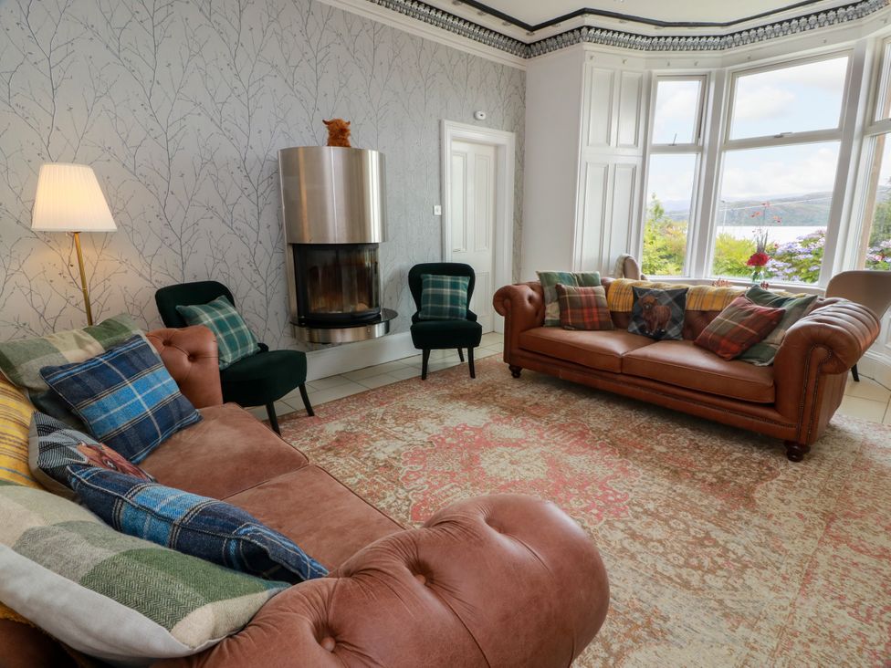 A living room with a fireplace and seating areas at Altafearn in Kames