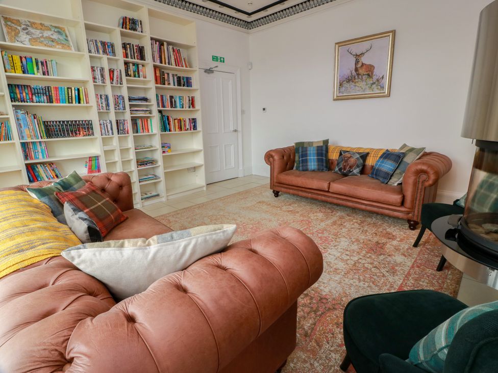 A living room with a bookshelf and two sofas at Altafearn in Kames