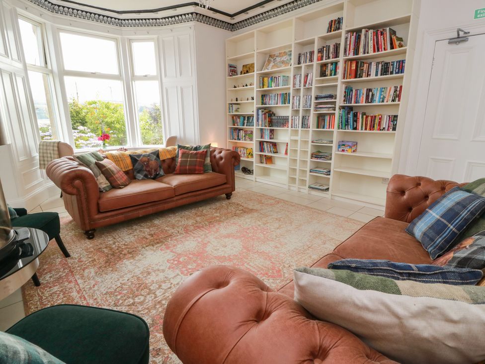 A living room with a sofa and bookshelf at Altafearn in Kames