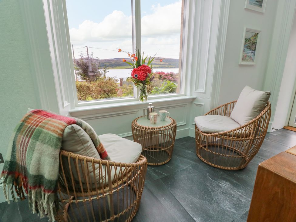 A snug with armchairs and a window view at Altafearn in Kames