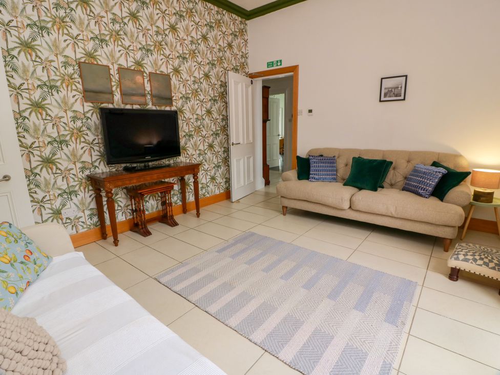 A living room with a sofa and television at Altafear in Kames