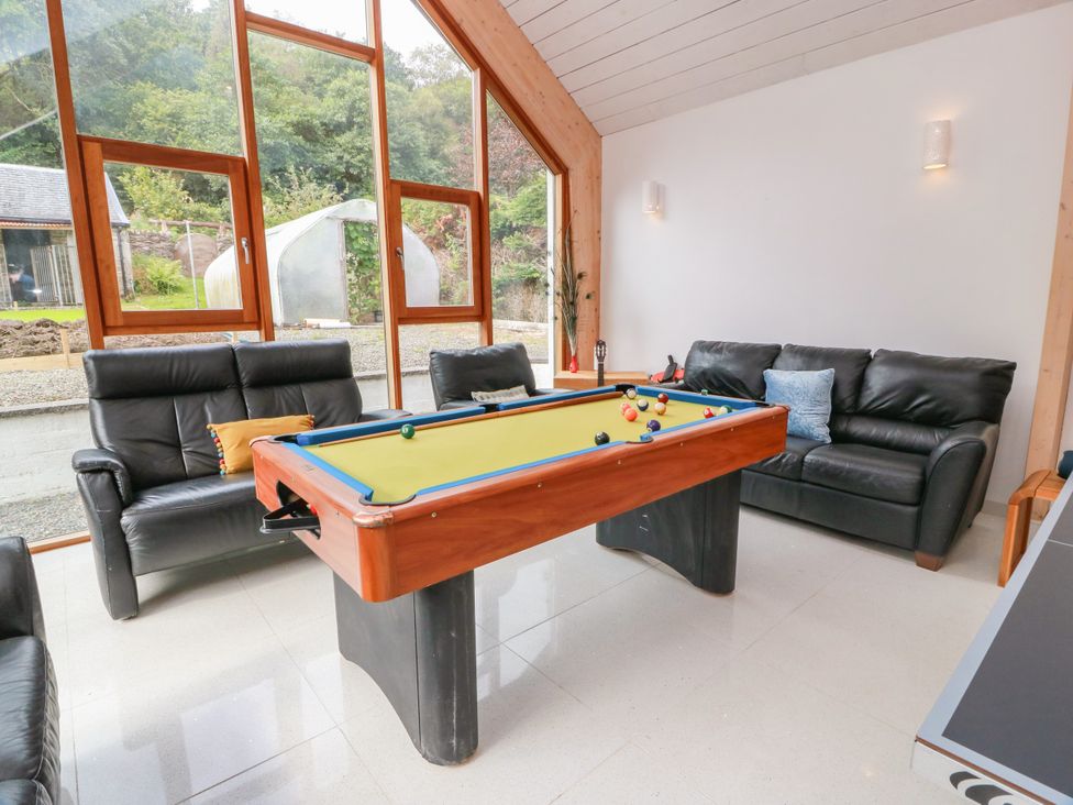 A game room with a pool table and sofas at Altafearn in Kames