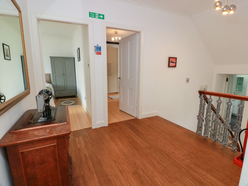 A hallway with a staircase and mirror at Altafearn in Kames