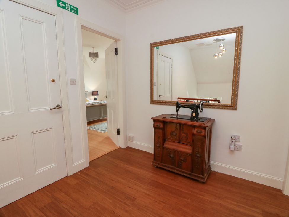 A hallway with a mirror and sewing machine at Altafearn in Kames