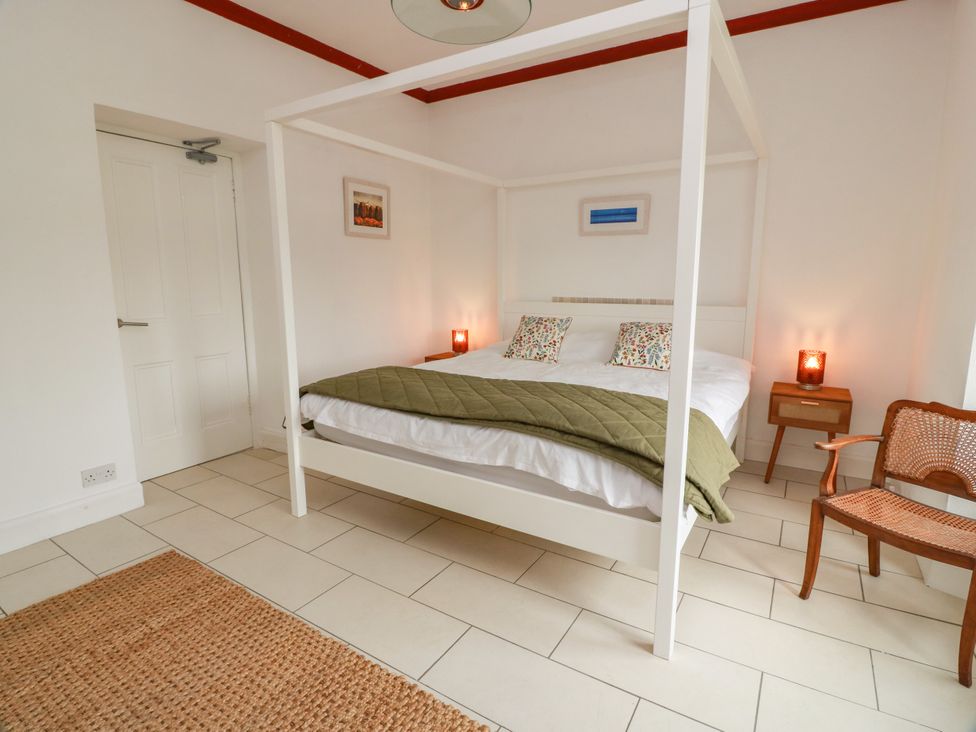 A bedroom with a four-poster bed and nightstand at Altafearn in Kames