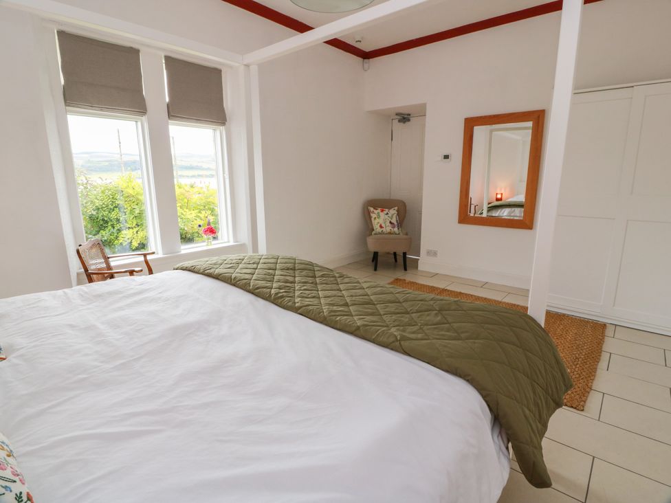 A bedroom with a bed and chair at Altafearn in Kames