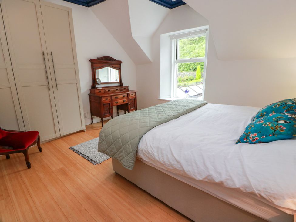 A bedroom with a bed and dressing table at Altafearn in Kames