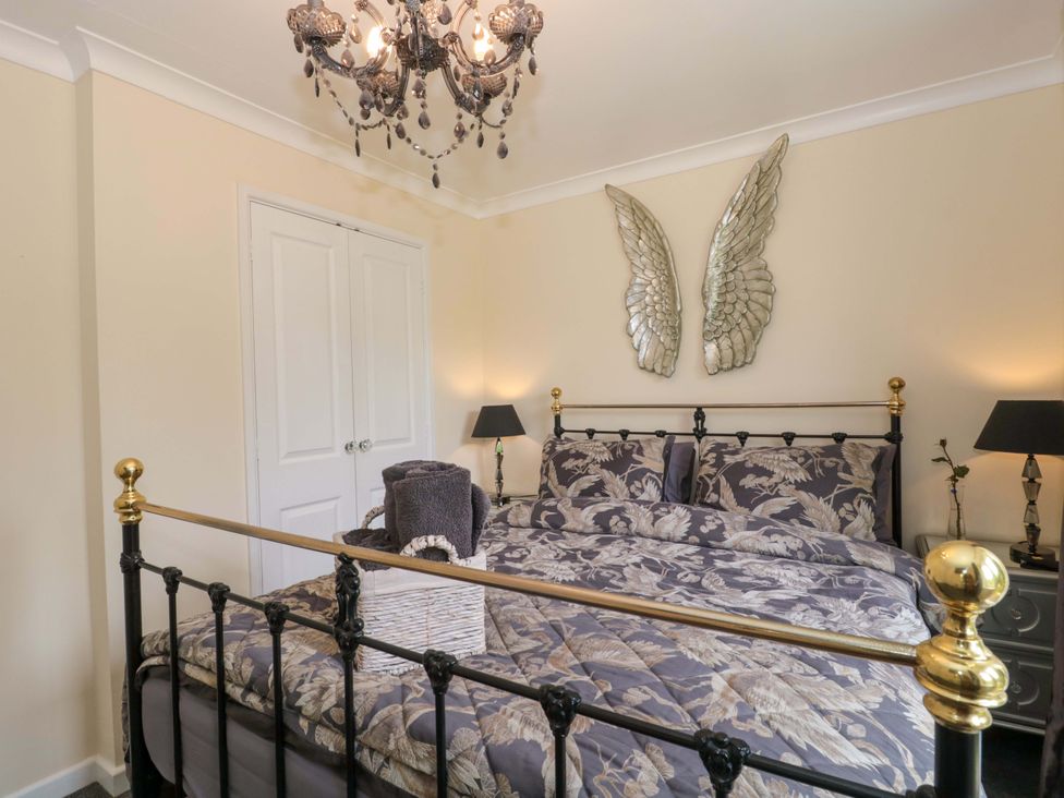 A bedroom with a bed and decorative wings at No 8 in Burnham-on-Sea