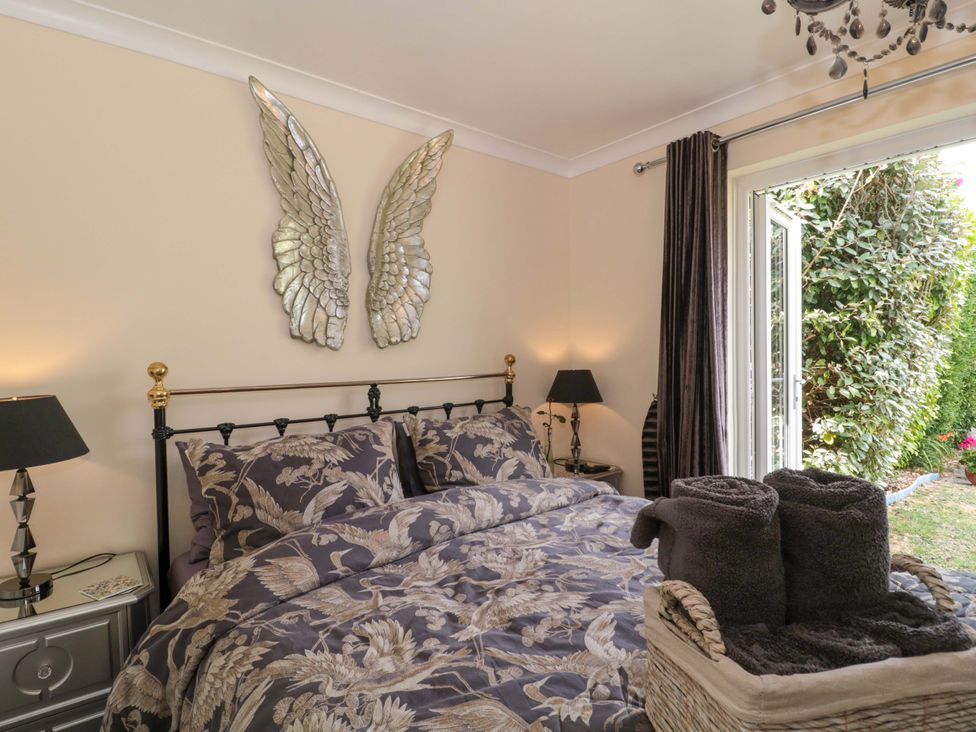 A bedroom with a bed and wall art at No 8 in Burnham-on-Sea