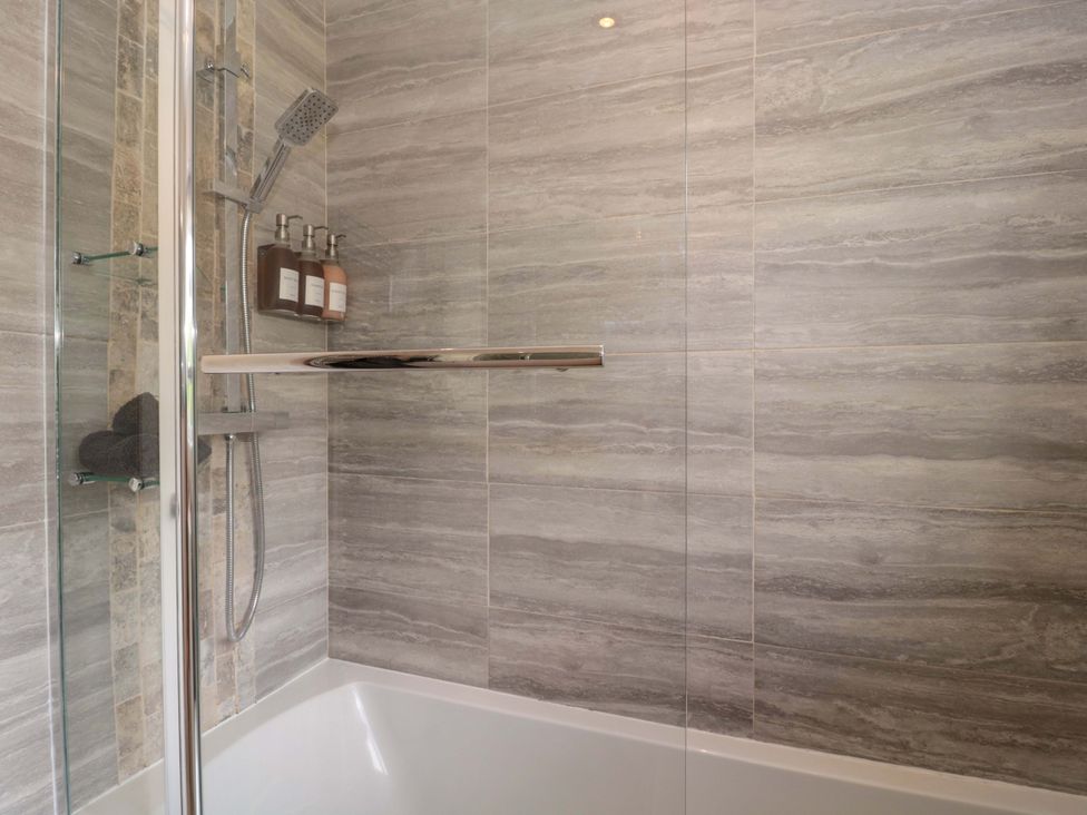 A bathroom with a shower and bathtub at No 8 in Burnham-on-Sea